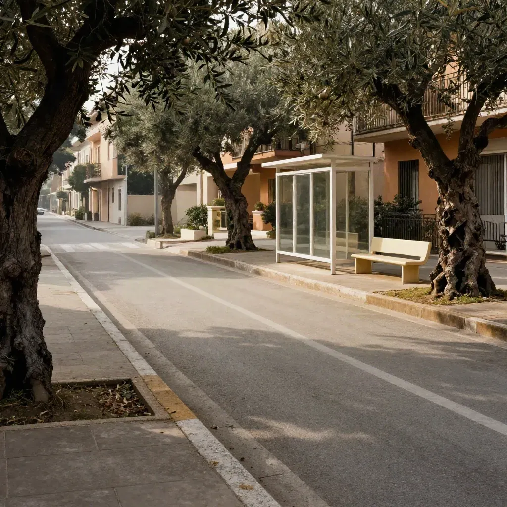 Incrocio residenziale con alberi, pista ciclabile, fermata bus, panchina e palazzi al sole